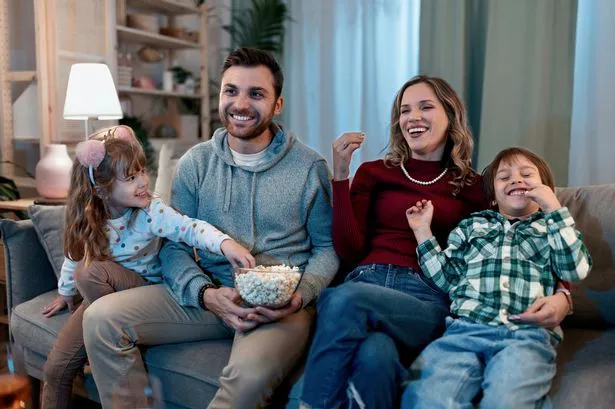 Family watching TV at home